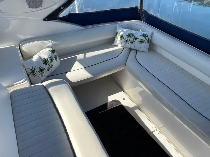 Slide: The Image of 2004 Maxum 2900 SCR boat interior with white seating and palm tree pillows. - 3