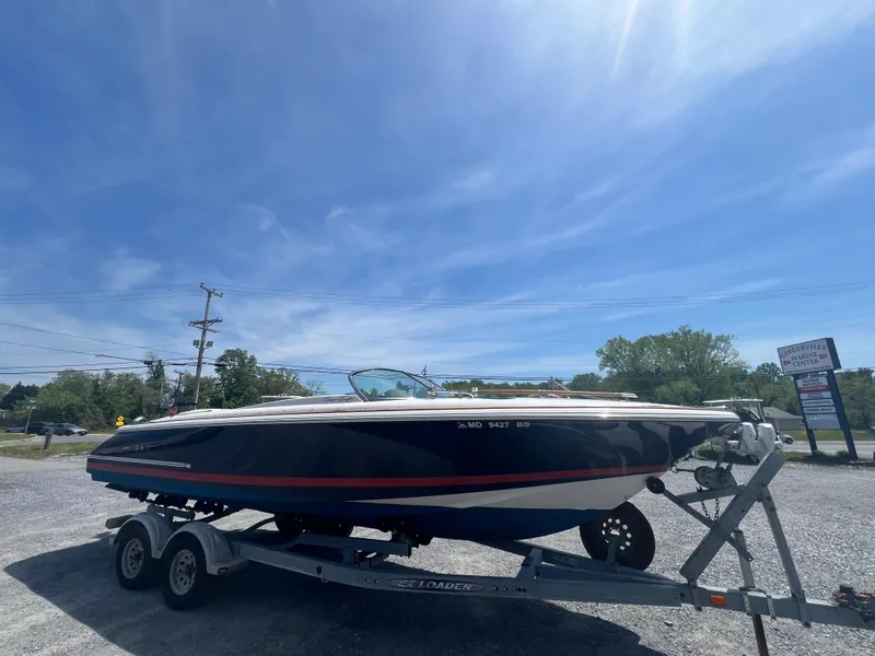 Slide: The Image of 2004 Chris-Craft Corsair 25 boat on trailer under clear blue sky. - 0