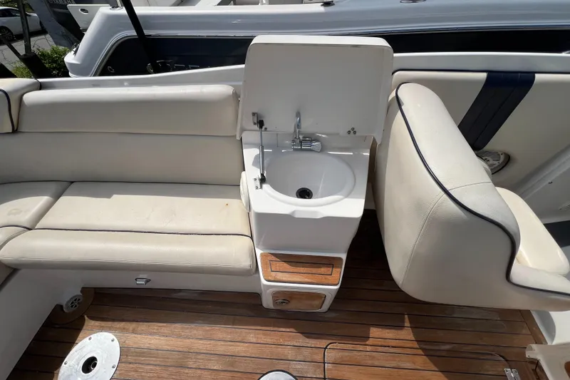 Slide: The Image of 2004 Chris-Craft Corsair 25 interior with sink, seating, and wooden flooring. - 10