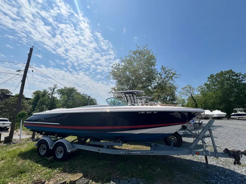 Slide: The Image of 2004 Chris-Craft Corsair 25 boat on trailer under clear blue sky. - 2