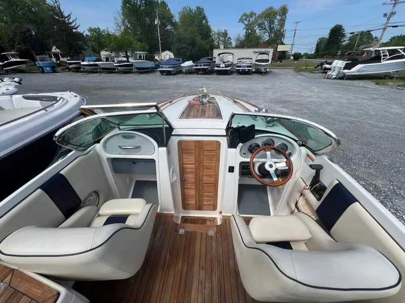 Slide: The Image of 2004 Chris-Craft Corsair 25 boat interior with wooden accents and leather seating. - 6