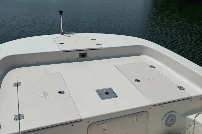 Slide: The Image of 2021 Carolina Skiff 21 LS boat deck with storage compartments, on calm water. - 9