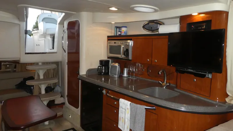 Slide: The Image of 2007 Sea Ray 340 Sundancer interior with kitchen, sink, microwave, and TV. - 20