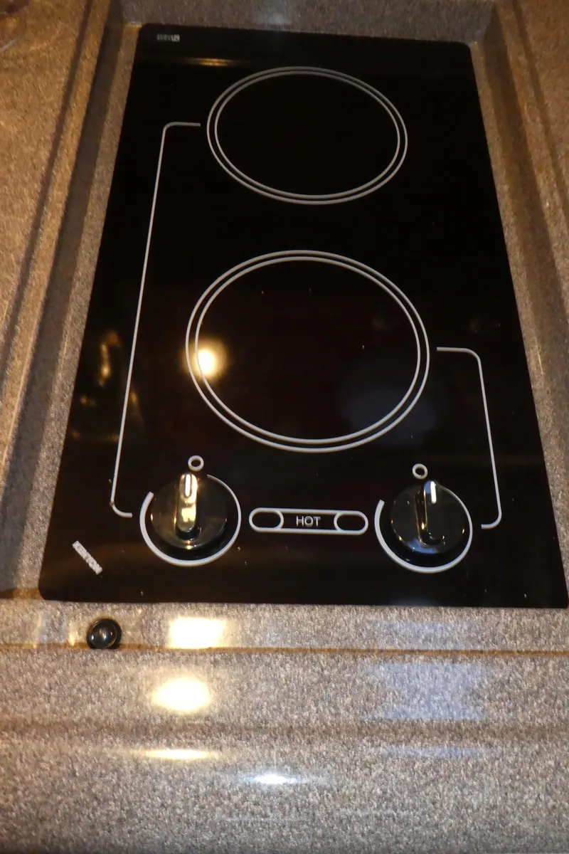 Slide: The Image of 2007 Sea Ray 340 Sundancer stovetop with dual burners and control knobs. - 22