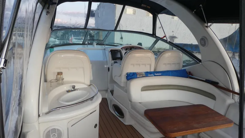 Slide: The Image of 2007 Sea Ray 340 Sundancer interior with helm, seating, and wooden table. - 7