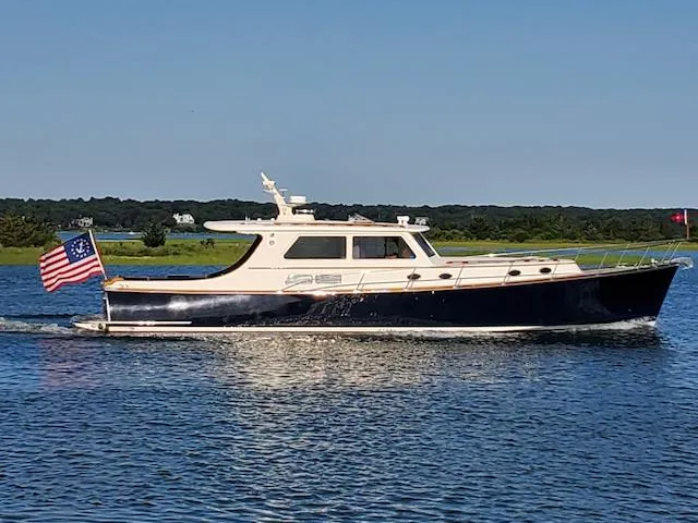 The Image of 2003 Vicem 51 Classic yacht cruising on a calm lake with American flag. - 0