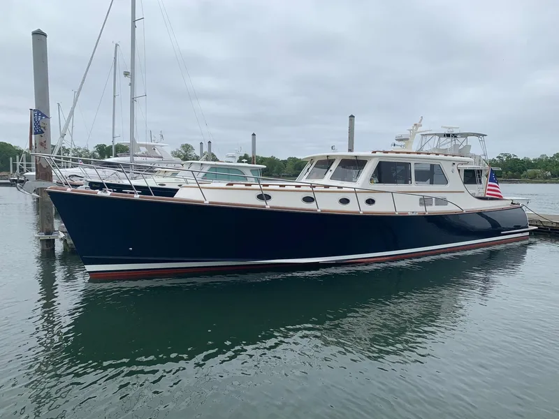 Slide: The Image of 2003 Vicem 51 Classic yacht docked in a marina, featuring a sleek navy hull. - 3