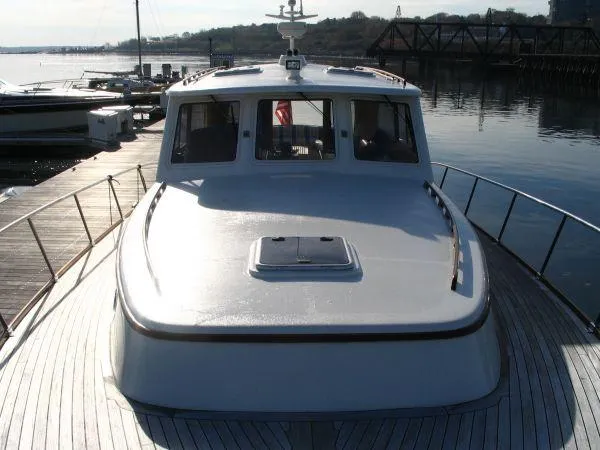 Slide: The Image of 2003 Vicem 51 Classic yacht docked at a marina, showcasing its sleek design and spacious deck. - 5