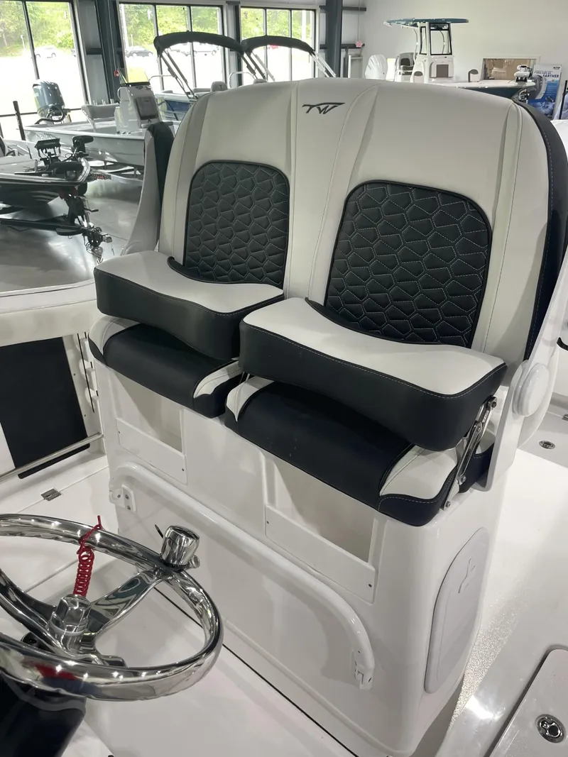 Slide: The Image of 2025 Tidewater 272 boat seats with black and white upholstery in a showroom. - 5