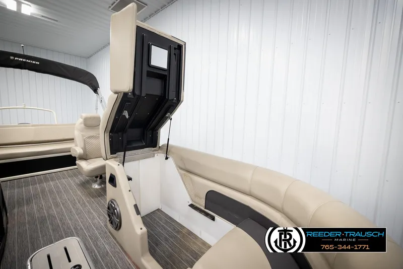 Slide: The Image of 2022 Premier 230 Solaris RL boat interior with beige seating and storage compartment open. - 22