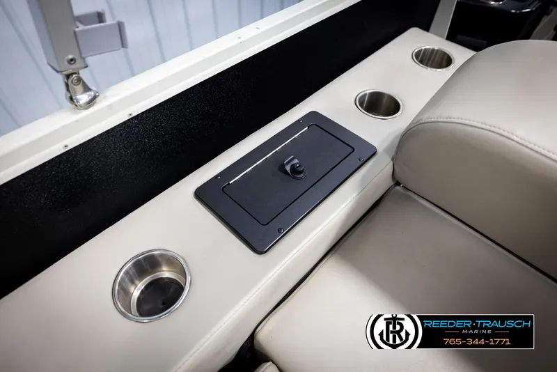 Slide: The Image of 2022 Premier 230 Solaris RL boat interior with cup holders and storage compartment. - 45
