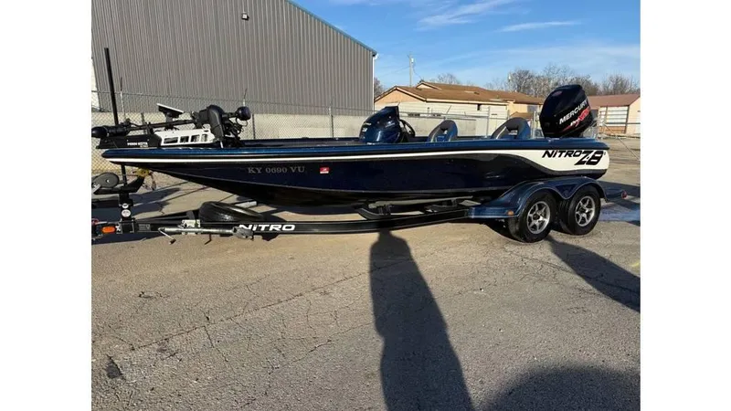 Slide: The Image of 2014 Nitro Z-8 boat on trailer, parked outdoors, with visible motor and dual axles. - 1
