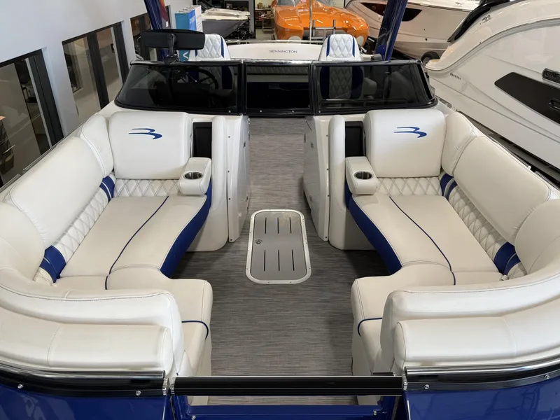 Slide: The Image of 2021 Bennington QX25 boat interior with white and blue seating, modern design, and spacious layout. - 15