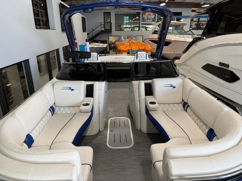 Slide: The Image of 2021 Bennington QX25 boat interior with white and blue seating in showroom. - 16