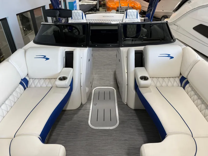 Slide: The Image of 2021 Bennington QX25 boat interior with white and blue seating, cup holders, and sleek design. - 17