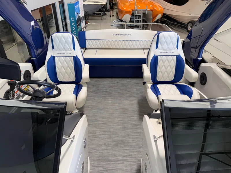 Slide: The Image of 2021 Bennington QX25 boat interior with blue and white seating, steering wheel, and modern design. - 21