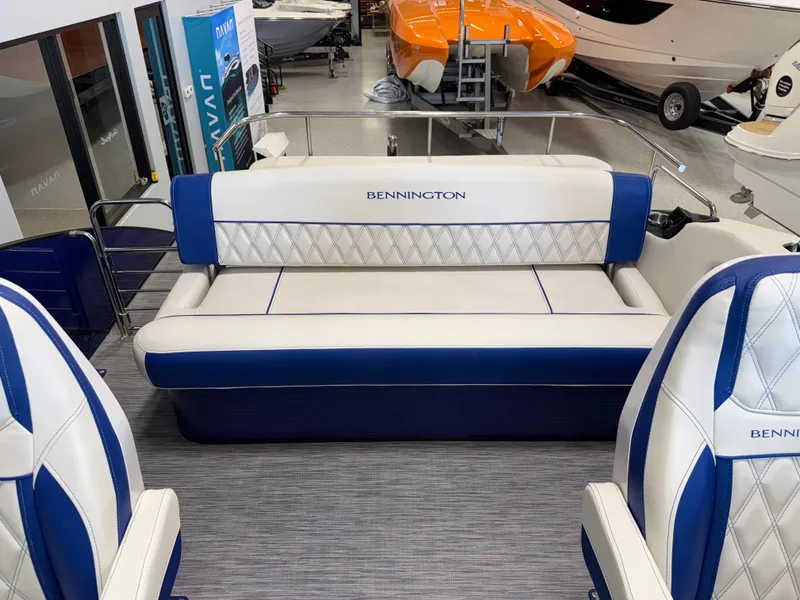 Slide: The Image of 2021 Bennington QX25 boat interior with blue and white seating in showroom. - 24