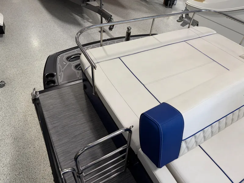 Slide: The Image of 2021 Bennington QX25 boat interior with white and blue seating, sleek design, and metal railings. - 27