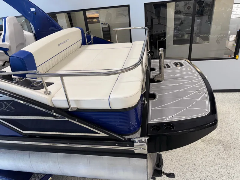 Slide: The Image of 2021 Bennington QX25 boat with sleek seating and modern design in showroom. - 30