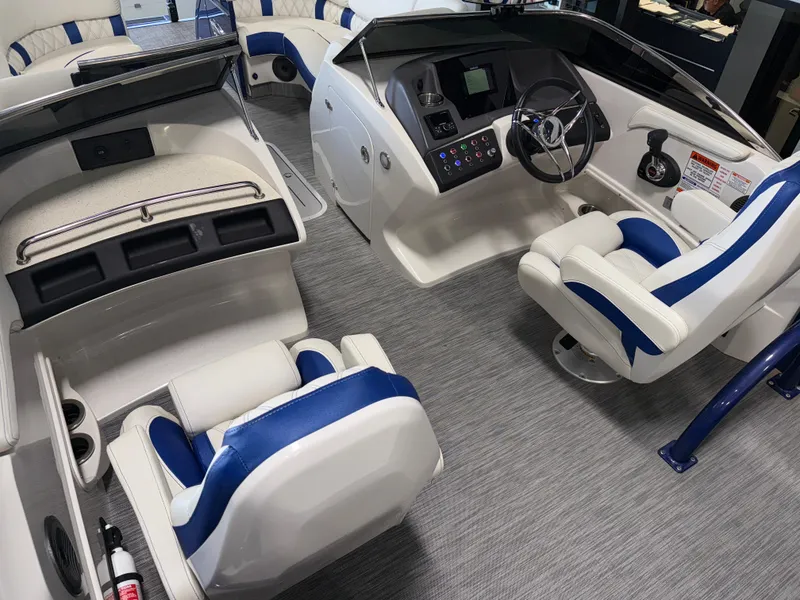 Slide: The Image of 2021 Bennington QX25 boat interior with modern helm, blue and white seating, and sleek design. - 33