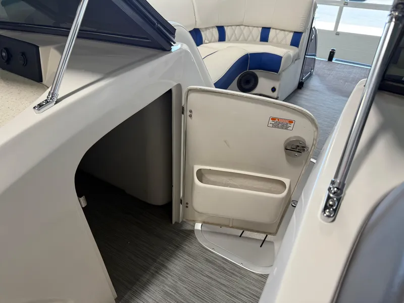 Slide: The Image of 2021 Bennington QX25 boat interior with open storage compartment and cushioned seating. - 38