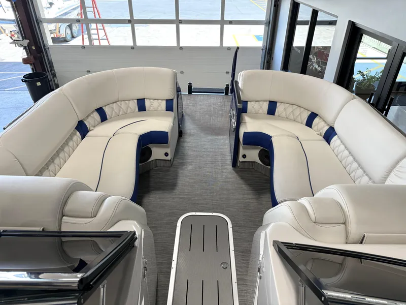 Slide: The Image of 2021 Bennington QX25 boat interior with luxurious white and blue seating. - 40