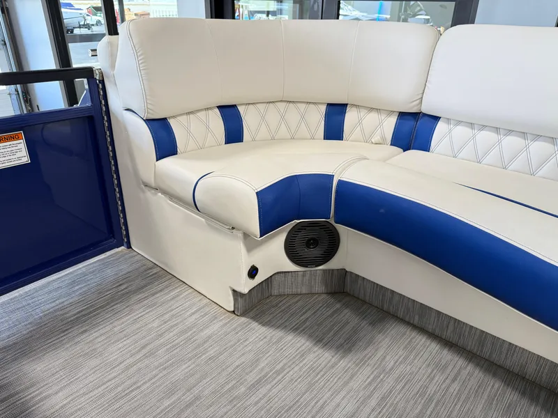 Slide: The Image of 2021 Bennington QX25 boat interior with white and blue cushioned seating. - 42