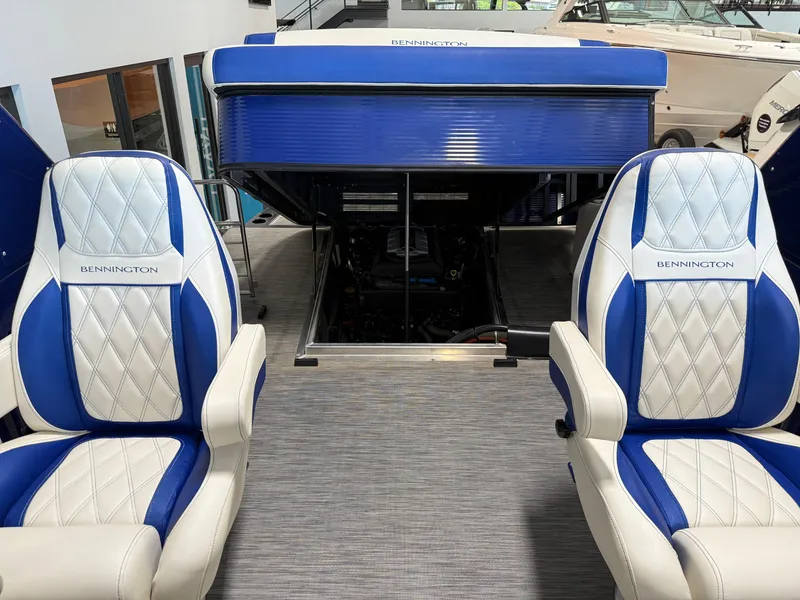 Slide: The Image of 2021 Bennington QX25 boat interior with blue and white seating and open engine compartment. - 43