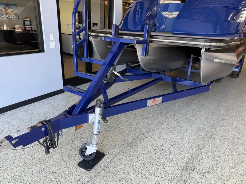 Slide: The Image of 2021 Bennington QX25 pontoon boat on a blue trailer in a showroom. - 47