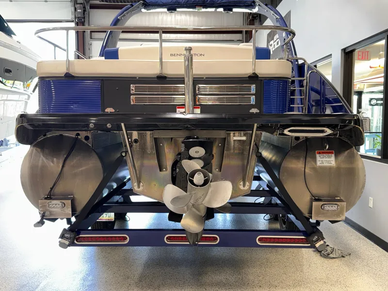 Slide: The Image of 2021 Bennington QX25 pontoon boat rear view with dual pontoons and propeller. - 9