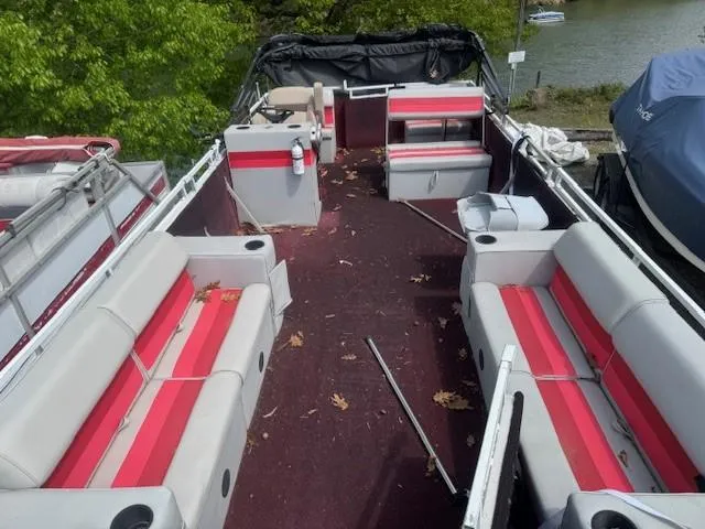 Slide: The Image of 1988 Skipper Craft 240 boat interior with red and gray seating, docked near a lake. - 5