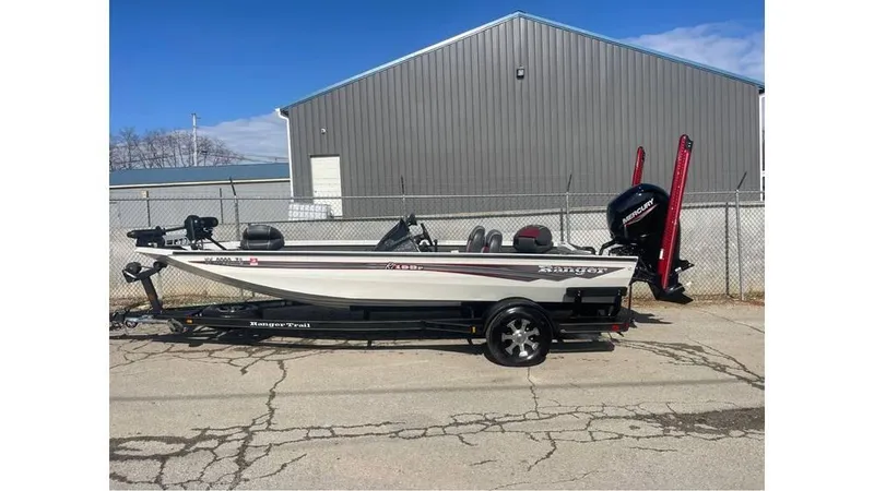 Slide: The Image of 2018 Ranger RT198P boat on trailer, parked near a metal building. - 1