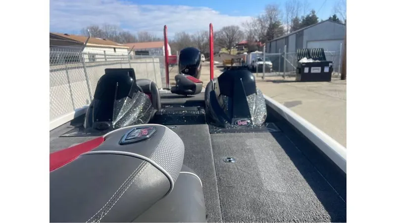 Slide: The Image of 2018 Ranger RT198P boat interior with dual seats and motor, parked outdoors. - 11