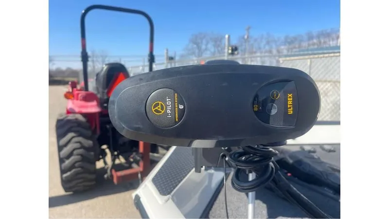 Slide: The Image of 2018 Ranger RT198P boat with Minn Kota Ultrex trolling motor, parked near a red tractor. - 6