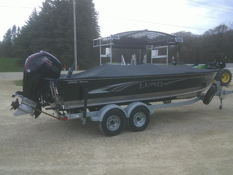 Slide: The Image of 2019 Lund 2000 Alaskan Tiller boat on trailer, covered and parked outdoors. - 18