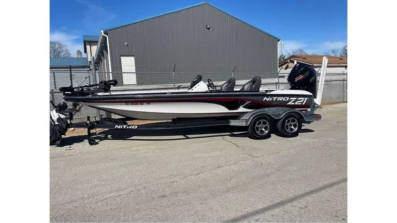Slide: The Image of 2020 Nitro Z21 boat on trailer, parked outdoors near a building. - 1
