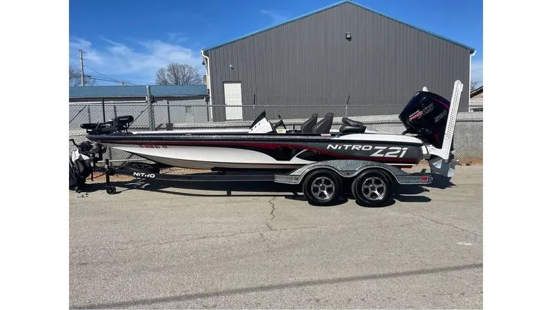 Slide: The Image of 2020 Nitro Z21 boat on trailer, parked outdoors near a gray building. - 5