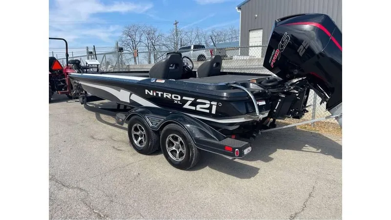 Slide: The Image of 2022 Nitro Z21 XL boat with trailer, parked outdoors near a building. - 4