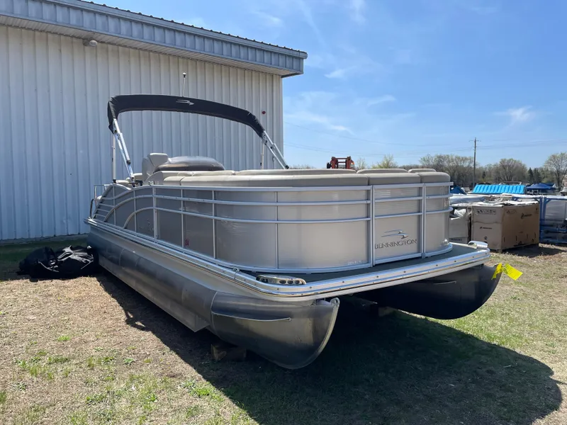 Slide: The Image of 2013 Bennington 2275 RCW pontoon boat parked outdoors near a metal building. - 3