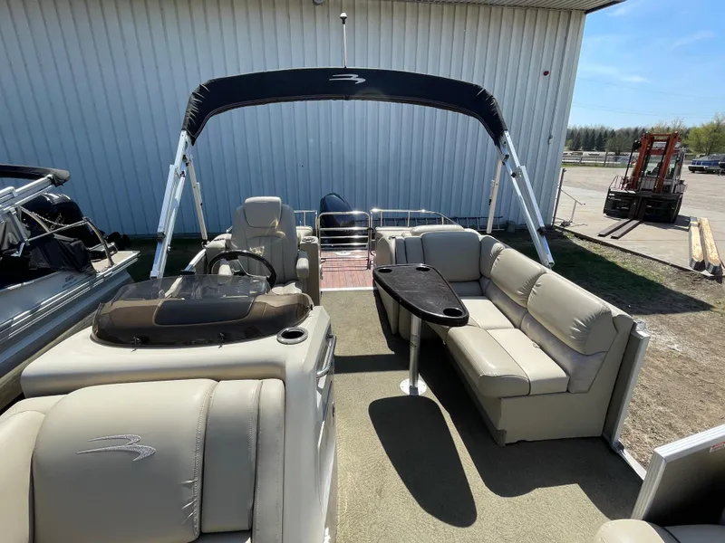 Slide: The Image of 2013 Bennington 2275 RCW pontoon boat with beige seating and black canopy. - 7