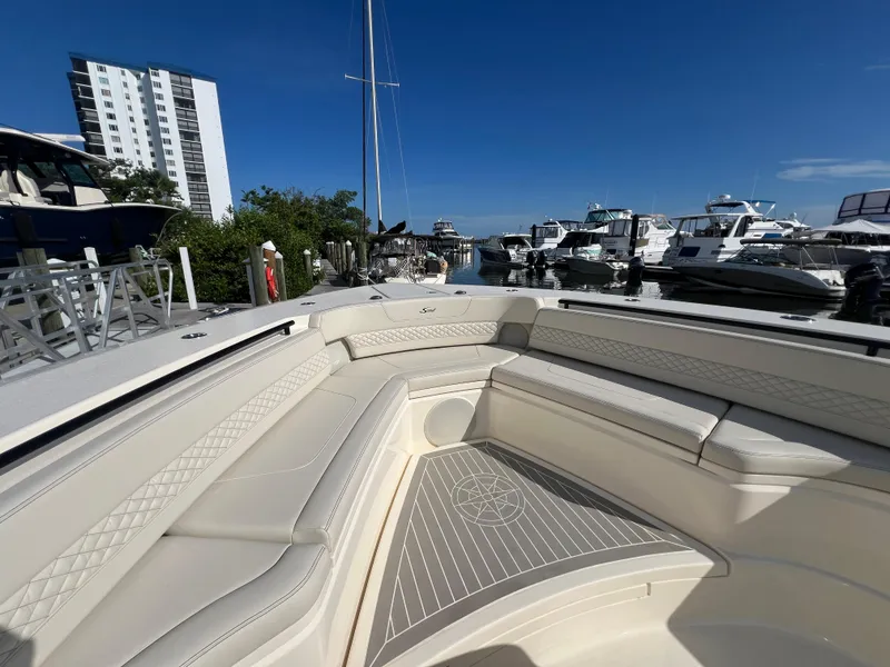 Slide: The Image of 2025 Scout 425 LXF boat interior with luxurious seating at a marina. - 11