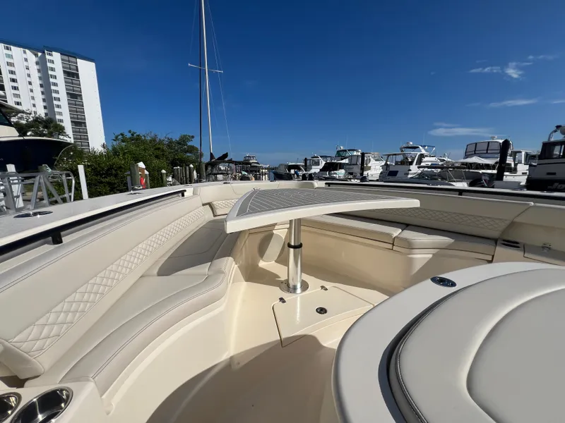 Slide: The Image of Luxurious 2025 Scout 425 LXF boat interior with elegant seating and table, docked at marina. - 12