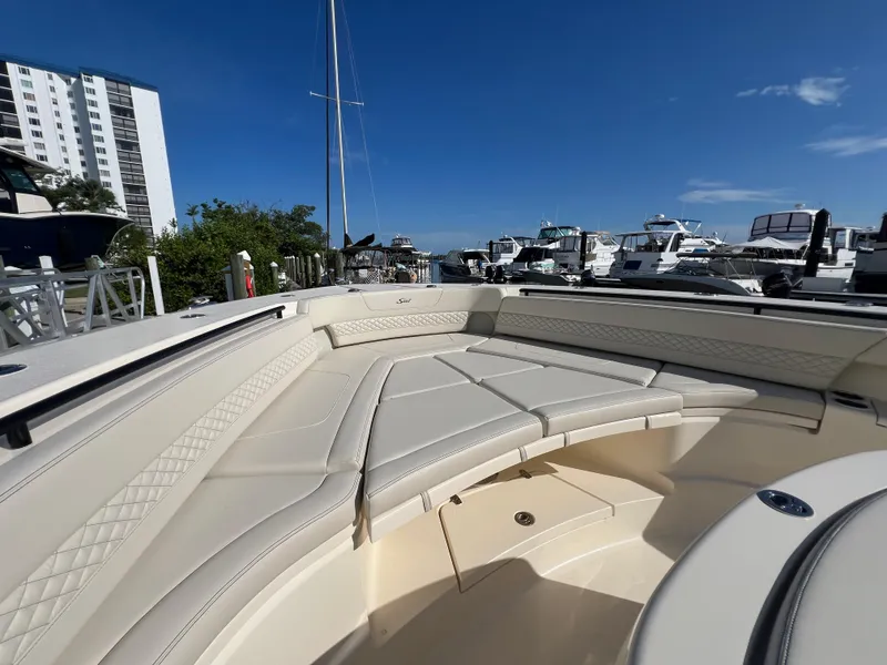 Slide: The Image of Luxurious 2025 Scout 425 LXF boat interior with plush seating at a marina. - 13