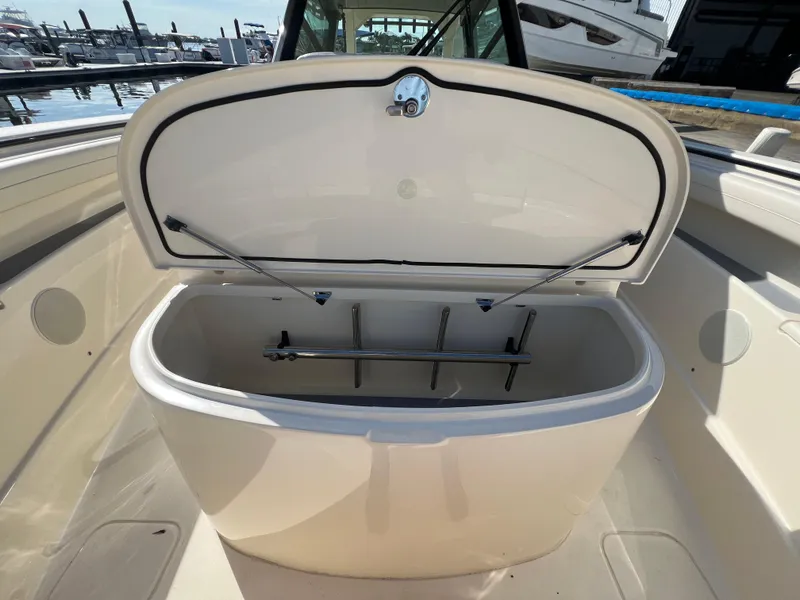 Slide: The Image of Open storage compartment on 2025 Scout 425 LXF boat, docked at marina. - 17