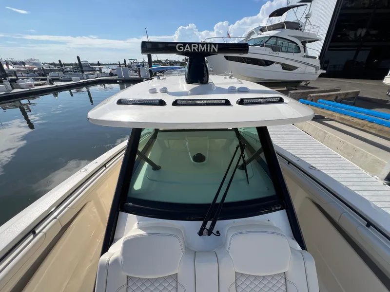 Slide: The Image of 2025 Scout 425 LXF boat docked, featuring Garmin equipment and sleek design. - 18