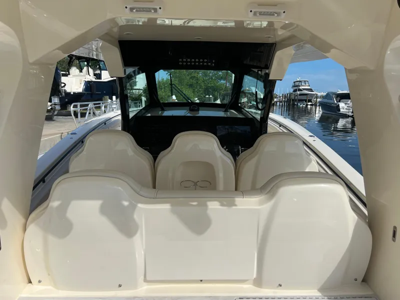 Slide: The Image of 2025 Scout 425 LXF boat interior with seating and helm, docked at marina. - 25
