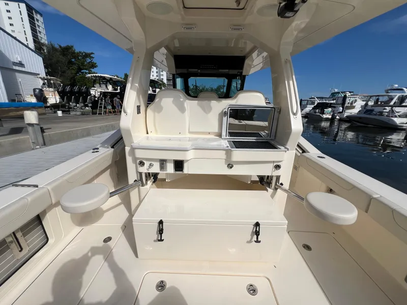 Slide: The Image of 2025 Scout 425 LXF boat interior with seating and grill at marina. - 29