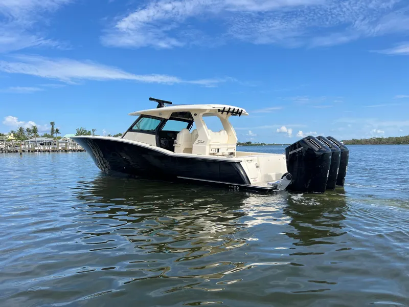 Slide: The Image of 2025 Scout 425 LXF boat on calm water under a clear blue sky. - 3