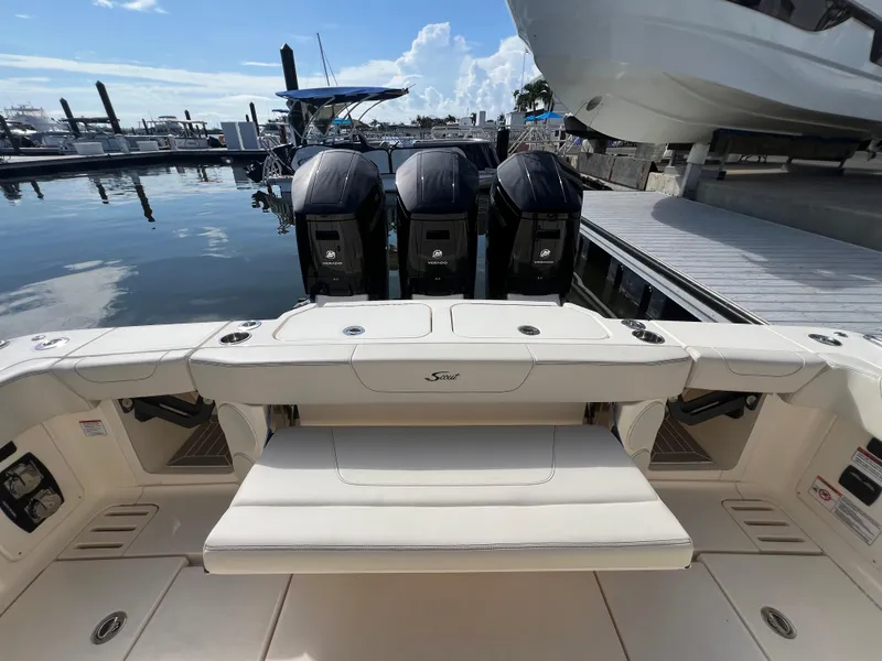 Slide: The Image of 2025 Scout 425 LXF boat with triple outboard engines docked at marina. - 30