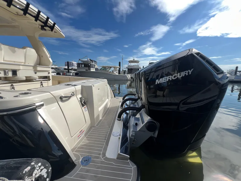 Slide: The Image of 2025 Scout 425 LXF boat with Mercury outboard engine at marina under blue sky. - 33